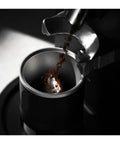 Espresso Gang Verified Shaker Funnel With Built In Dosing Cup For 58mm Portafilter pouring coffee grounds into funnel.