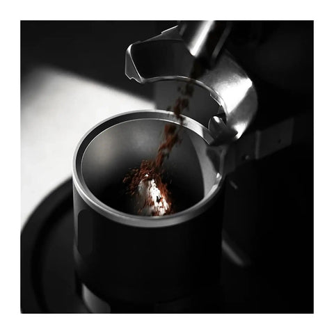 Espresso Gang Verified Shaker Funnel With Built In Dosing Cup For 58mm Portafilter pouring coffee grounds into funnel.