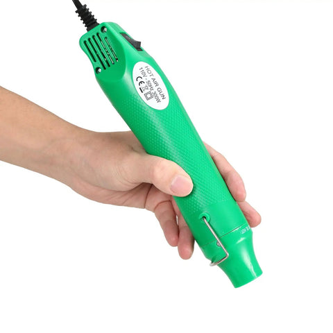 Person holding a portable green 110V 300W handheld heat gun with non-slip handle, 3.28ft cable, ideal for crafting and DIY projects.