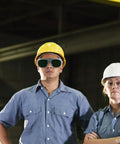 Heavy Duty Pair Of Welding Goggles With Double Layer Plastic Lens worn by workers in a shop setting for safety during tasks.