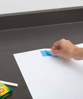 Person using Blue Double Sided Duct Tape Roll 1.4 Inch By 12 Yards With Aggressive Natural Rubber Adhesive on paper