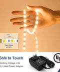 Lit 82ft Dimmable 24V White LED Strip Lights Tunable 3000K To 6000K Rope Light held in hand with power adapter