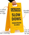 Caution Slow Down Pedestrians In Area Folding Floor Sign 25 By 12 Inches Plastic Black On Yellow Big And Bright Double Sided Durable Sign With Easy Carry Handle For Indoor Or Outdoor Use.