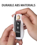Hands holding Porsche Key Fob Cover Kit 3 Piece Painted Key Shell Set For Cayenne Panamera Macan 911 Boxster Cayman white, durable ABS material.