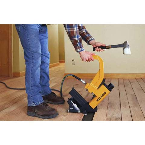 Person using a Flooring Nailer Rolling Base With Tool Free Thickness Adjustment on wood floor, showing non-marring wheels