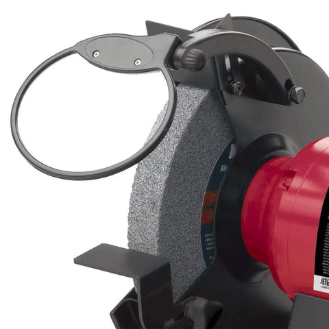 Powerful Eight Inch Bench Grinder Boots Kickin Three Quarter Horsepower Motor focus on grinding wheel with protective guard.