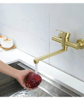 ntumLeap Brushed Nickel Wall Mounted Kitchen Faucet 180° Rotating Hot & Cold Water Mixer Dual Hole Basin Tap in use with an apple.