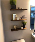 Wall shelves supported by 20 Pack Heavy Duty L Corner Brackets 5x3 Inch Black Shelf Braces for shelves, displaying decor items.