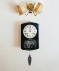 Wall-mounted clock with a black case and pendulum below decorative lamp. Two Pack Cuckoo Clock Weights With Chains For Mechanical Pendulum Movement Replacement Parts, Decorative Wall Clock Accessories For Living Room And Office, Vintage Rustic Home Decor Accent.