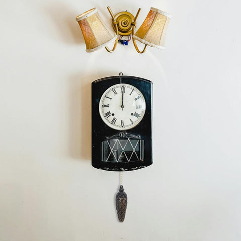 Wall-mounted clock with a black case and pendulum below decorative lamp. Two Pack Cuckoo Clock Weights With Chains For Mechanical Pendulum Movement Replacement Parts, Decorative Wall Clock Accessories For Living Room And Office, Vintage Rustic Home Decor Accent.