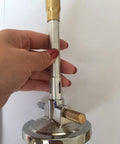Hand holding a Bunsen Burner With Air And Gas Adjustment And Flame Stabilizer For Natural Gas And Propane Lab Heating Tool