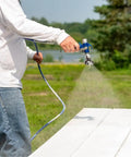 Person using Airless Spray Gun For Paint Sprayers, 7250 PSI Capacity, Aircraft Grade Aluminum Body outdoors on wooden surface.