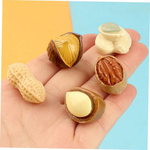 Hand holding 5 pieces of 20 Pieces Miniature Nut Models For Dollhouse Decor And Resin Crafts Realistic Tiny Food Props For DIY Projects