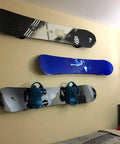 Rock Solid Aluminum Wall Mount Snowboard Rack With Hella Secure Eva Grip Pads holding three snowboards and bindings on a wall.