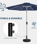 80 Pound Round Patio Umbrella Base With Fillable HDPE Weights For Outdoor Market Umbrellas Sturdy Heavy Duty Stand Fits 1.0 To 1.9 Inch Poles For 6 To 12 Foot Umbrellas Black shown with umbrella pole in windy conditions.