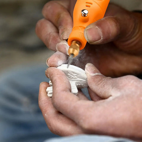 Person using Mini Cordless Rotary Tool Kit With 105 Accessories on a small white object, detailing work visible