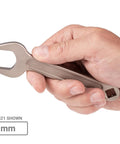Hand holding a 21 mm wrench from 20-Piece Metric Service Wrench Set with Short-Handled Open-End Wrenches, 15-Degree Angled Heads, 19 To 38 Mm, Heavy-Duty USA-Made Tool Kit For Auto Repairs And Mechanical Projects.