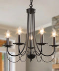 Five Light Farmhouse Chandelier in black with classic candle ceiling light fixture, featuring lit candles in modern room setting.