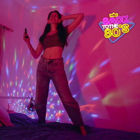Woman in room with 'Back to the 80's' neon sign and colorful lights on walls