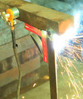 Front view of a 600A magnetic welding ground clamp installed on a steel frame during welding.
