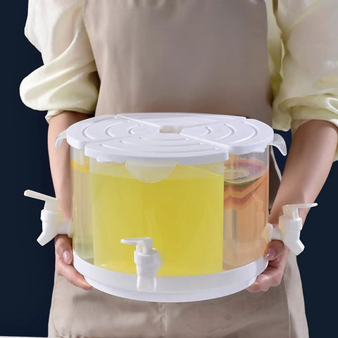 Five Point Five Liter Rotating Beverage Dispenser With Four Separate Compartments And Dripless Spigot in use, dispensing drinks with a sleek white finish.
