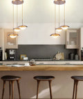 Go-To Three-Light Modern Pendant Lighting With Double Shades And White Glass Globe Inside Brushed Brass UFO Fixture over kitchen island