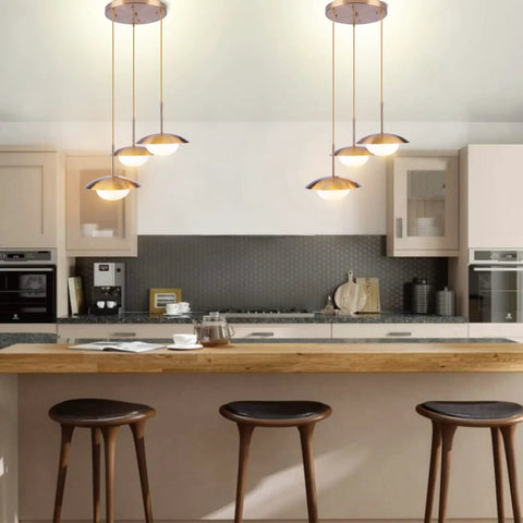 Go-To Three-Light Modern Pendant Lighting With Double Shades And White Glass Globe Inside Brushed Brass UFO Fixture over kitchen island
