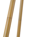 Close-up of faux wood tripod base for 60 Inch Floor Lamp With Faux Wood Tripod Base And Rattan Shade On Off Rotary Switch For Easy Control Cottagecore Cozy Vibe Living Room Lighting Modern Farmhouse Style Warm Ambience Sturdy Floor Lamp.