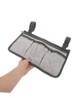 Hand holding Must Have Bedside Organizer Bag With Four Pockets And Cup Holder, Universal Bed Rail Caddy, gray with dark gray trim.