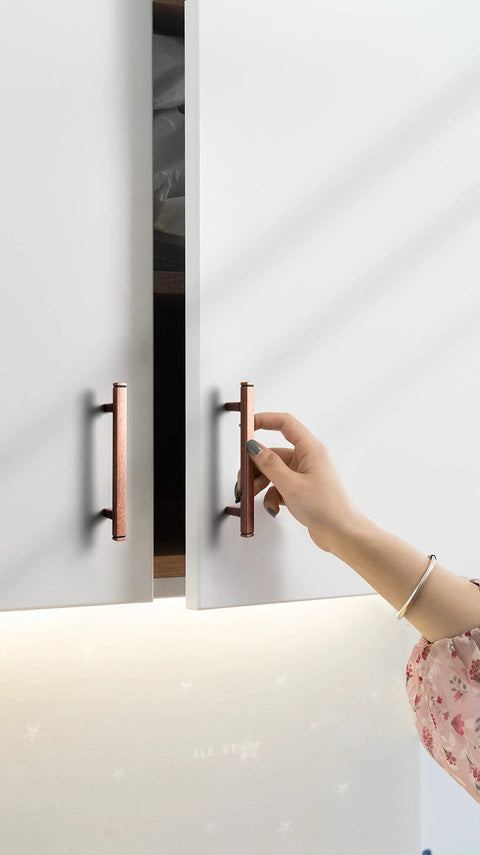 Person opening cabinet with Six Pack 3 Inch Hole Center Antique Copper Zinc Alloy Cabinet Pulls For Kitchen Drawers 4.73 Inch Length
