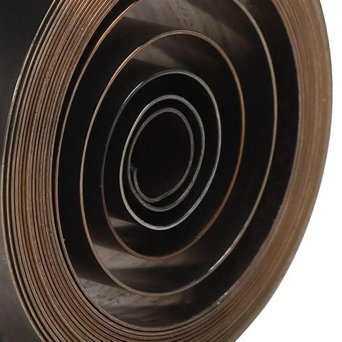 Close-up of a rolled Copper Main Watch Spring Replacement Part for Do It Yourself Pros and Watchmakers, 1.93-inch clock spring.