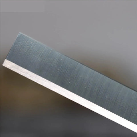 Close-up view of a Pro Grade 12 Inch Planer Blade, HSS steel, precision ground for woodworking tools, sharp edge detail.