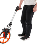 Heavy Duty Digital Measuring Wheel With Quick Brake And Tap To Reset Zero, Solid Aluminum Alloy Walking Tape Measure Roller For Land Survey And Site Measurement, Built Like A Tank being used by a person.