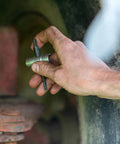 LockNLube grease fitting multi-tool (Small), metal tool held in a dirty hand.