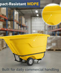 Commercial Grade Tilt Truck Dump Cart 850 Lb Capacity Zero Point Five Cubic Yard Yellow Rotational Molded Waste Bin side view in warehouse.
