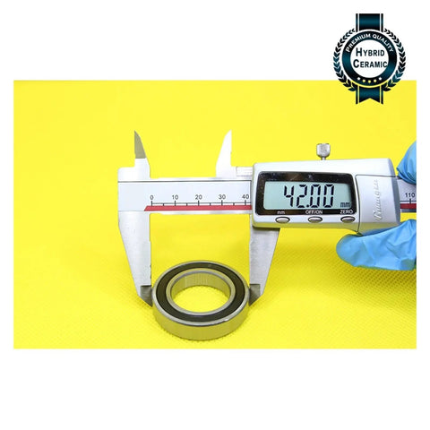 6905 Hybrid Ceramic Bearing 25X42X9MM ABEC-1 Si3N4 Steel Rings being measured with a caliper at 42mm on a yellow background.