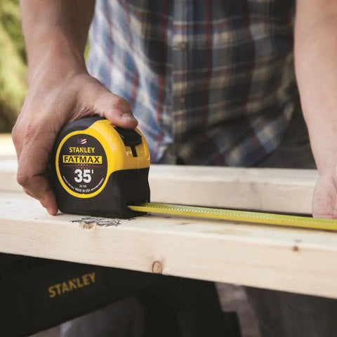 Person using 35 Foot Tape Measure With BladeArmor Coating On First 6 Inches on wood for heavy duty framing