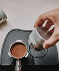 Hand using 53mm Gravity Adaptive Espresso Distributor for 54mm Portafilters, Fits Breville Bottomless Portafilter, 304 Stainless Steel Coffee Tool
