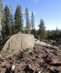 Multicam Camo Netting for Tactical Shelters and SmartFrame Systems set up in a forest terrain, showcasing rugged camouflage.