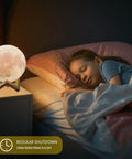 Dope 3D Moon Lamp Upgrade Night Light With 16 LED Colors Wooden Stand next to sleeping child in bedroom
