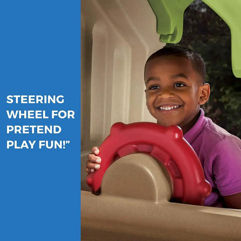Child playing with red steering wheel on Tot Friendly Outdoor Kids Playset With Two Tier Swing Set, Slide, Climber, Crawl Space And Playhouse.