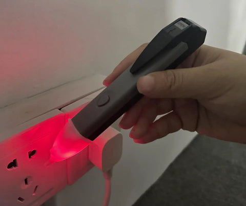 Hand using Non Contact Voltage Tester Pen With Led Flashlight And Buzzer Alarm AC Voltage Detector From 60V To 1000V on wall outlet