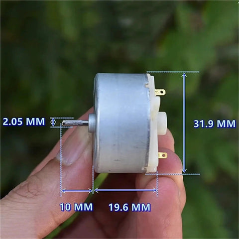 Close-up of Tiny Powerhouse Mini DC Motor For DIY Projects 32mm Round Spindle With Carbon Brush dimensions side view in hand.