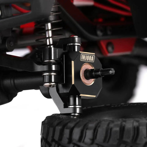Close-up of Beefy Brass Caster Blocks C Hubs And Steering Knuckle Kit With Black Hard Coat And Etched Logo on TRX4M 1/18 RC Crawler.