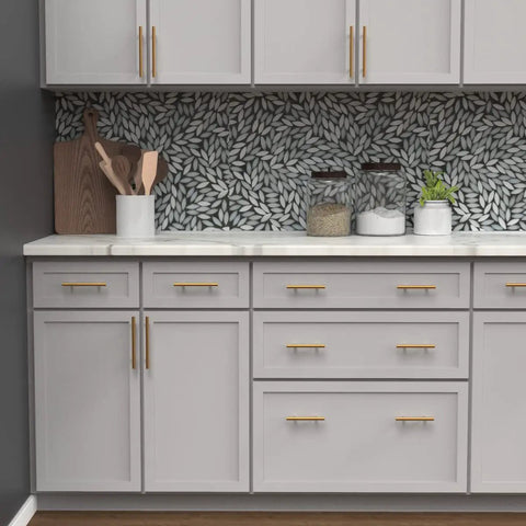 Modern kitchen scene with 10 Pack 3-Inch Center Cabinet Handles with Brushed Brass Finish on sleek gray cabinets.