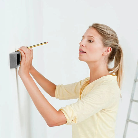 Woman using OSPSHPG Multifunctional Wall Scanner to detect studs and wires on a wall with a pencil in hand.