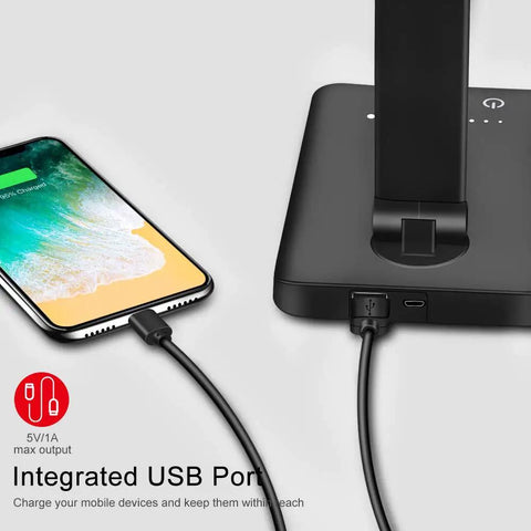 Go-To Multifunctional LED Desk Lamp With USB Charging Port, phone charging on base, black color visible, close-up angle.