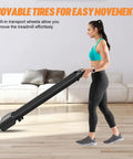 User demonstrating the movable tires of the Slick Foldable Treadmill With Bright Led Display And Handy Remote Control for easy transport.
