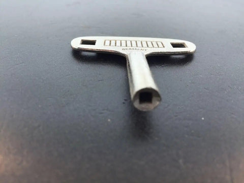 Replacement Clock Key N3 3mm For German 400 Day Miniature Clock DIY Repair Kit on black surface in close-up view