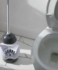 Heavy Duty Toilet Plunger With Hideaway Holder Caddy next to an open toilet showing its compact design and non-skid base.